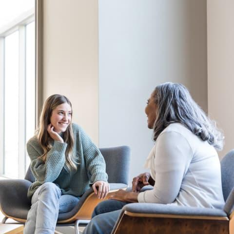 Photo of a professor and student sitting and talking with one another