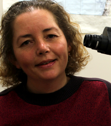 Laure Dubreuil smiling beside a microscope