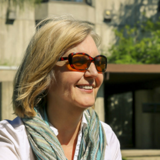 Side view head shot out of doors, smiling, wearing sunglasses