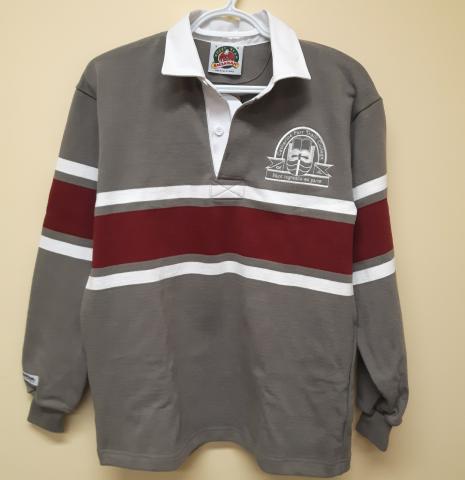 A grey, rugby-style polo shirt with a white Traill College logo in the upper left corner and a white collar. There is a large maroon stripe running horizontally across the centre of the shirt and sleeves with thinner white lines above and below.