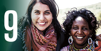 2 women smiling at the camera in a third-world country wearing brightly coloured scarves