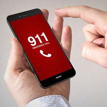 person picking up a phone and dialing 911