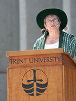 Dr. Bonnie Patterson speaking at a podium outside Bata Library during Convocation ceremonies