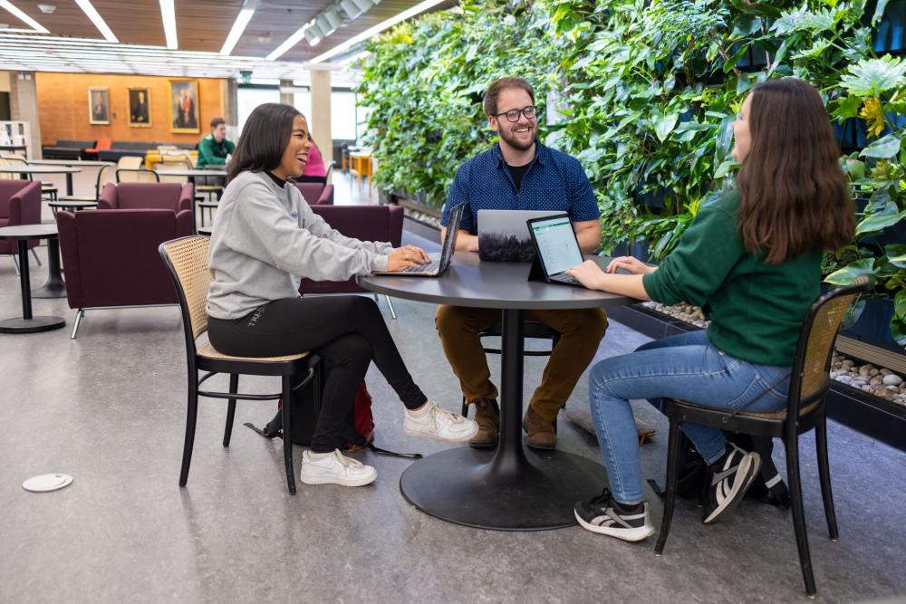a group of students sitting around a table at the library 