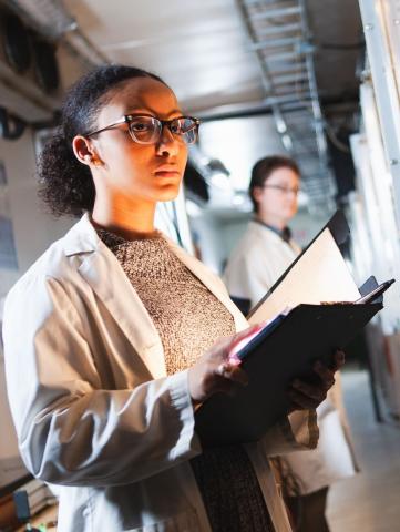 student in lab with notebook