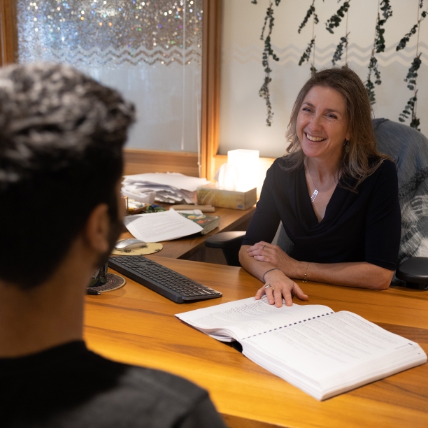 An Academic Advisor and a student at a desk reviewing the Academic Calendar