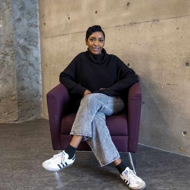 Raine, a transfer student, seated in a purple chair in Trent’s Bata Library 