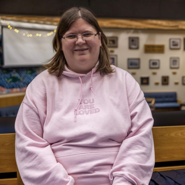 Tiiu, a transfer student, seated on a wooden bench in a student space on Trent’s Campus 