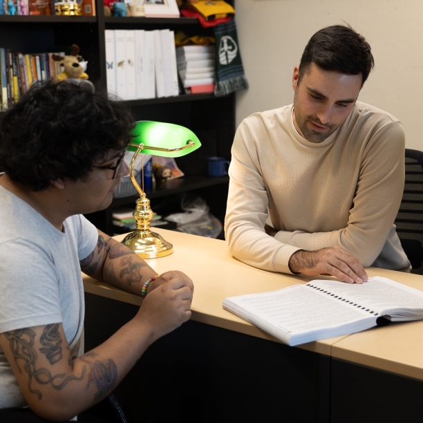 An Academic Advisor and a student at a desk reviewing the Academic Calendar