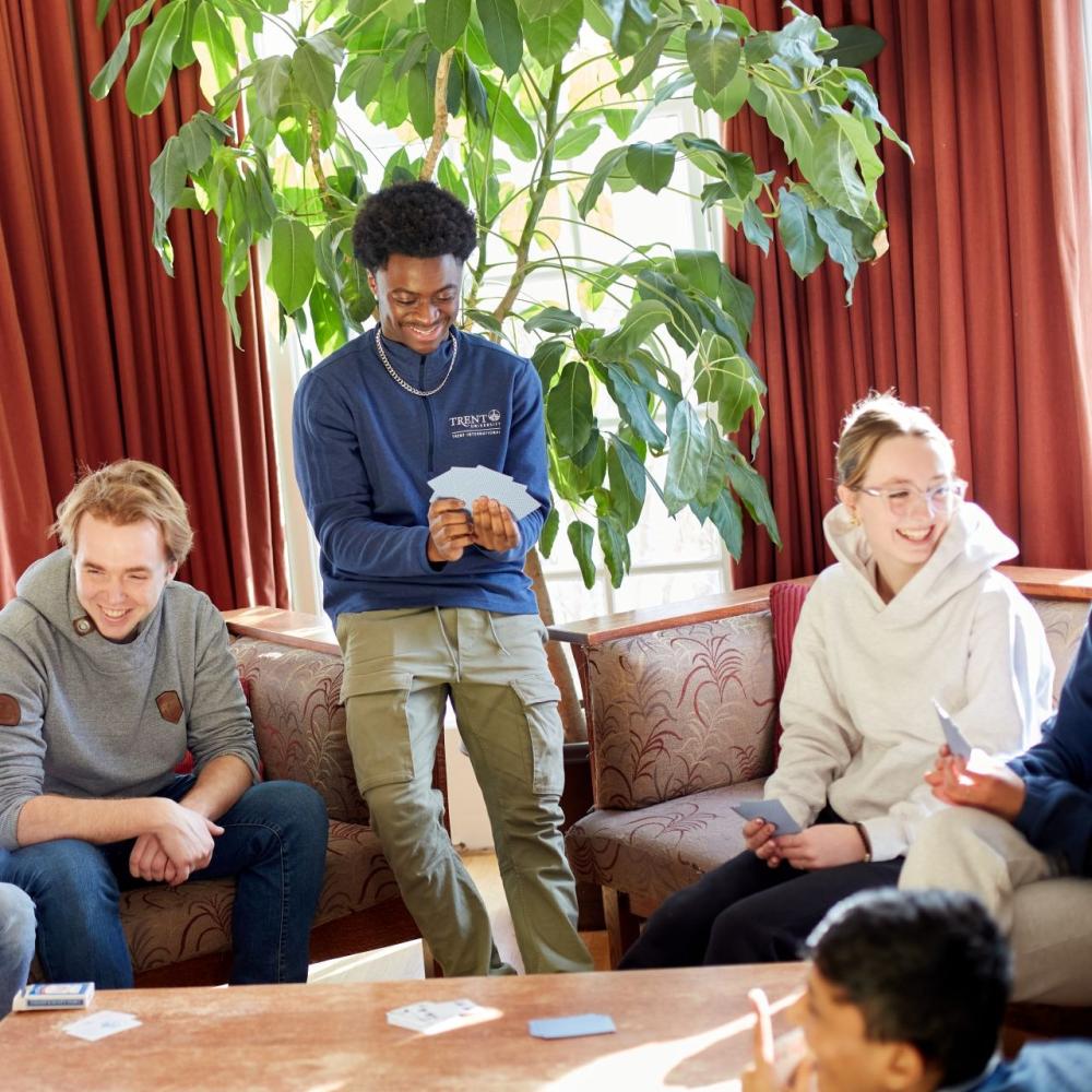 Students sitting in a common room, playing a game of cards