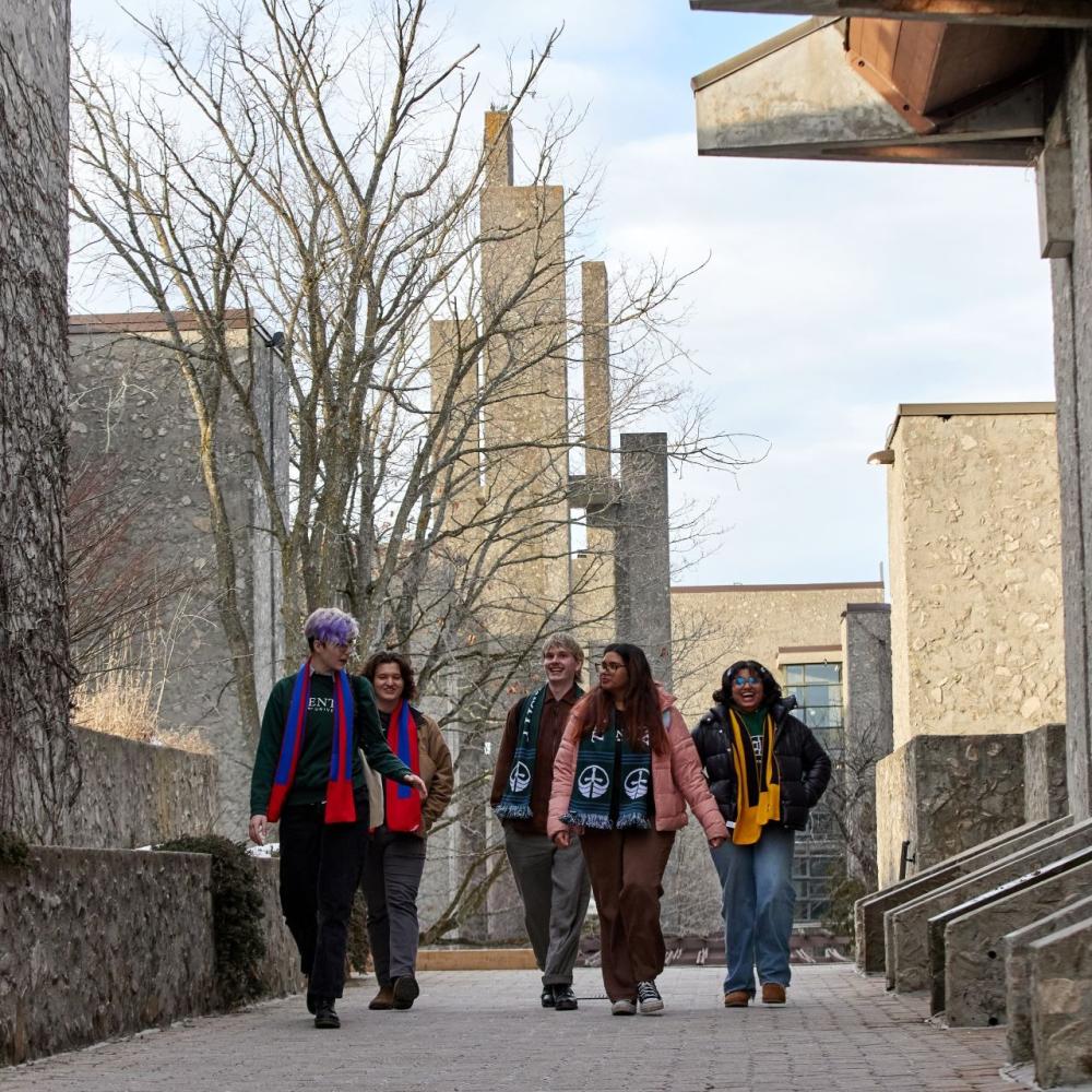 Five students wearing Trent scarves, walking together outside