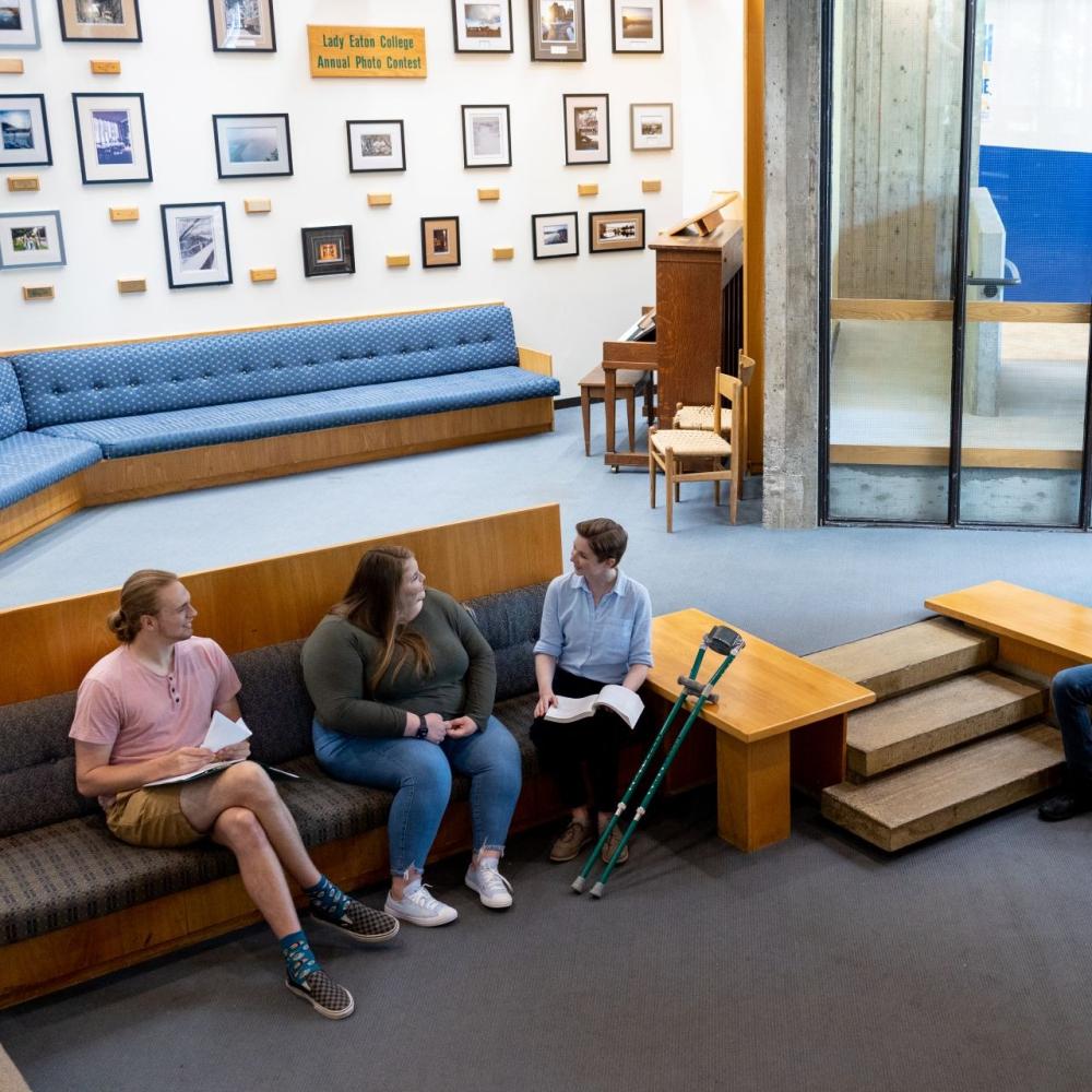 Three students sitting in a common room, chatting