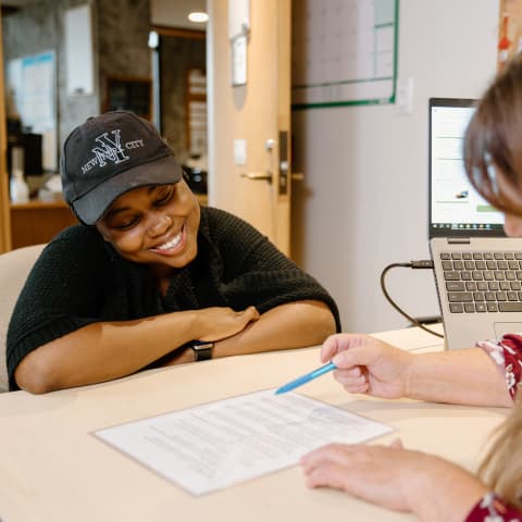 An advisor sitting opposite a student helping them