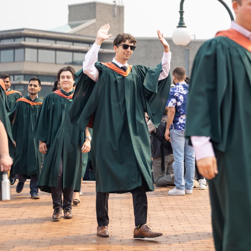Photo of graduate cheering in line to graduate