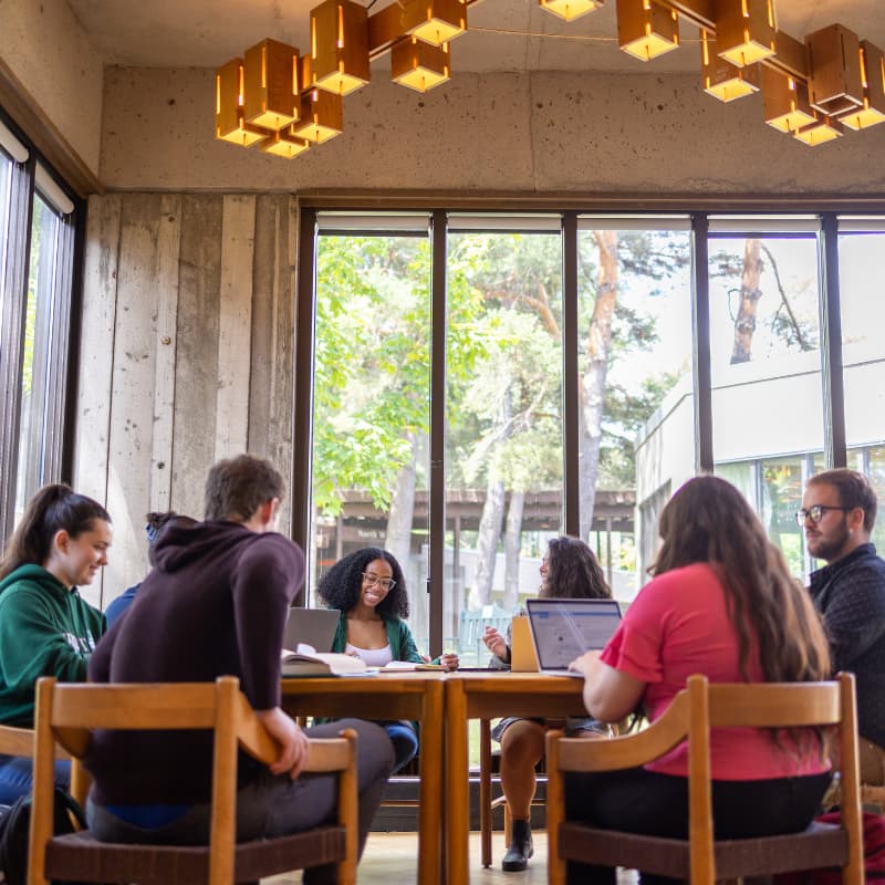 Photo of a group of people sitting around a table talking.