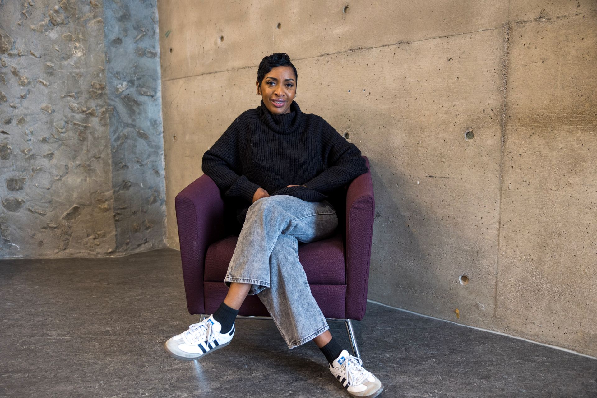 Student seated in the Library facing the camera and smiling