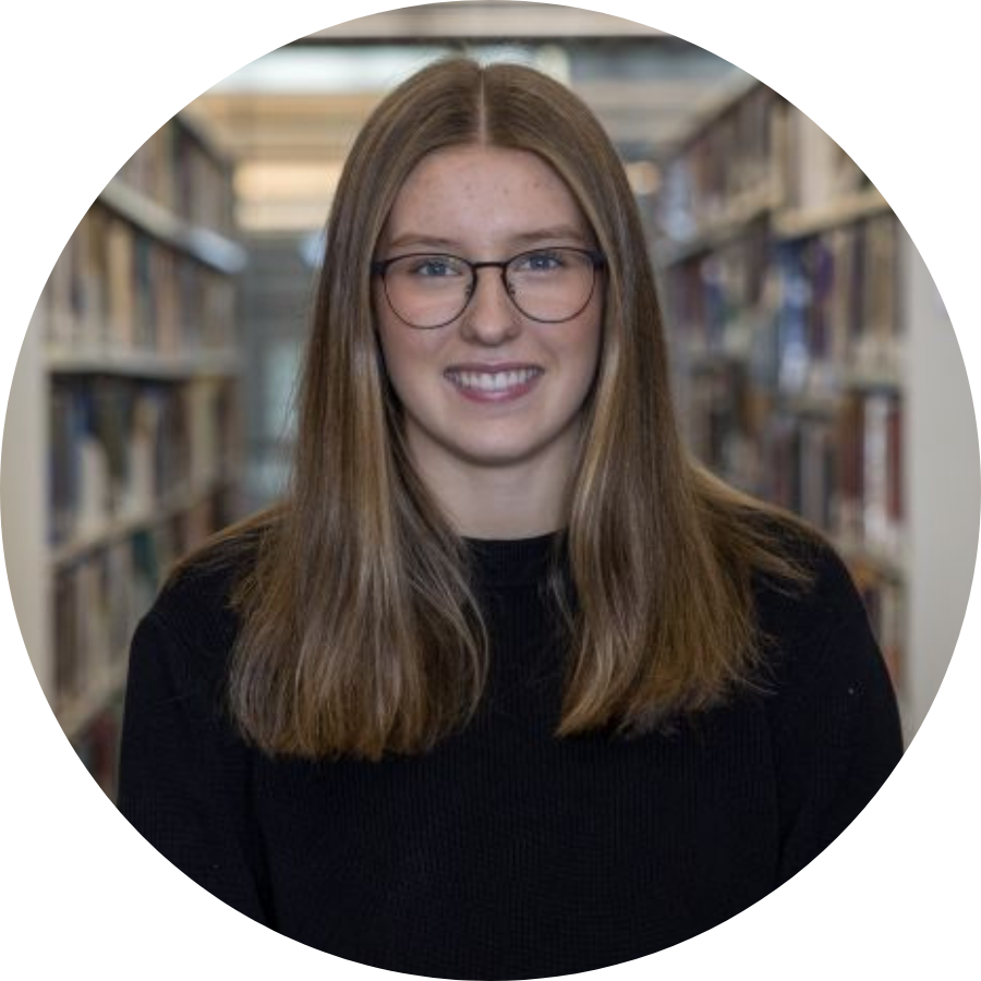 Emily, a transfer student, standing between stacks of books at Trent’s Bata Library 