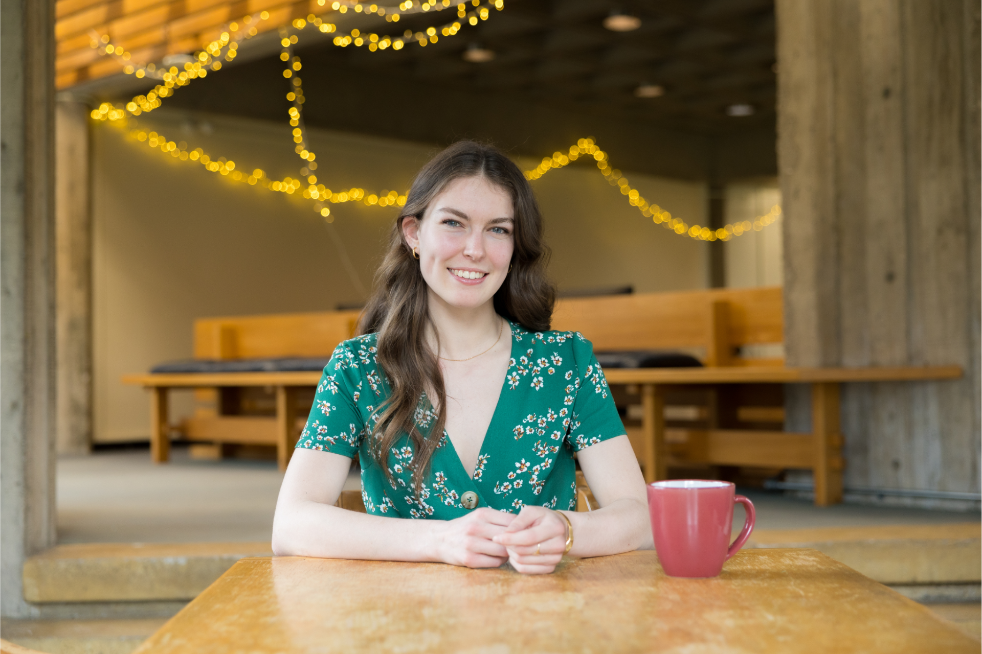 Katie, a transfer student, seated at a table in a student space on campus 