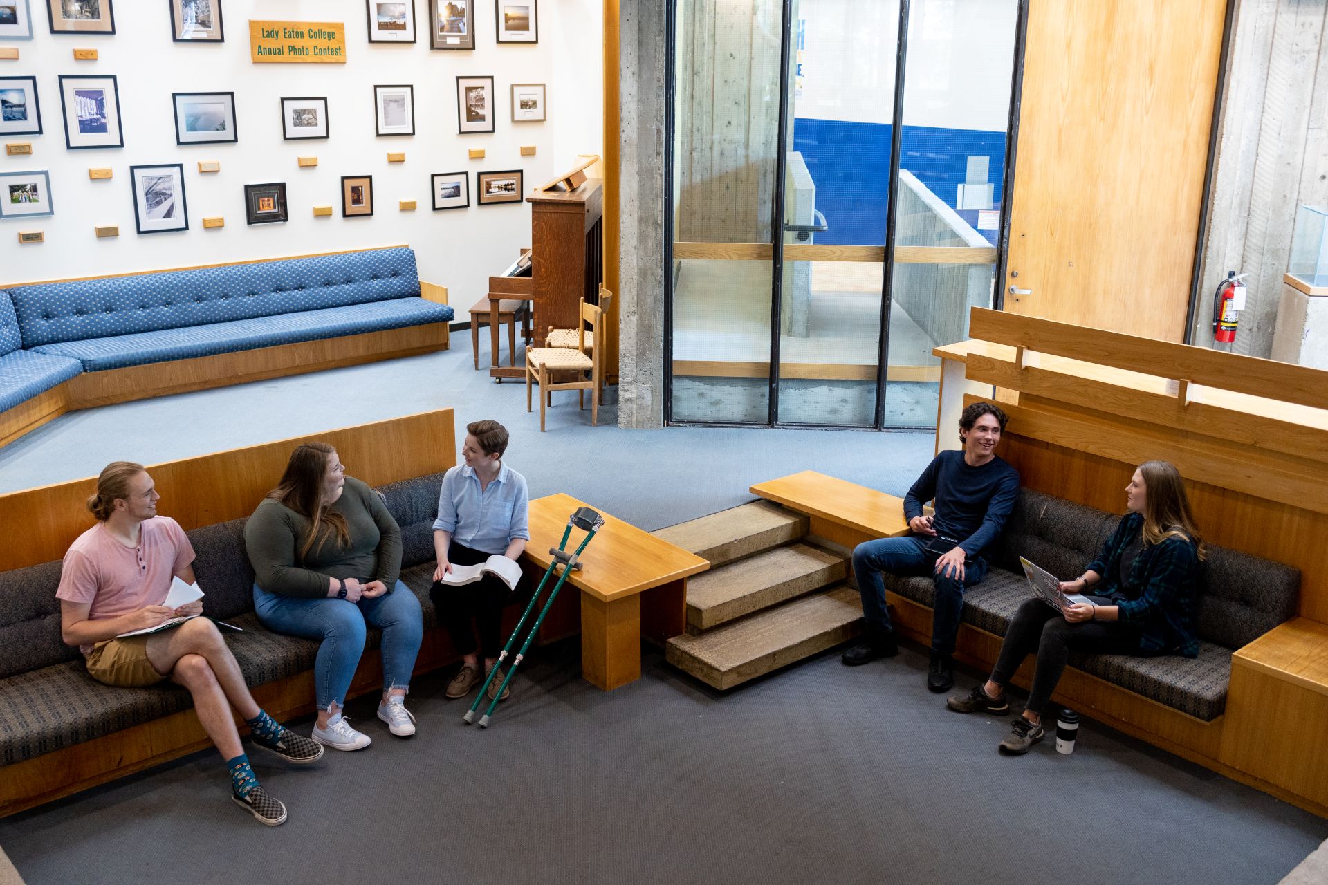 Five students sitting in a common room, chatting