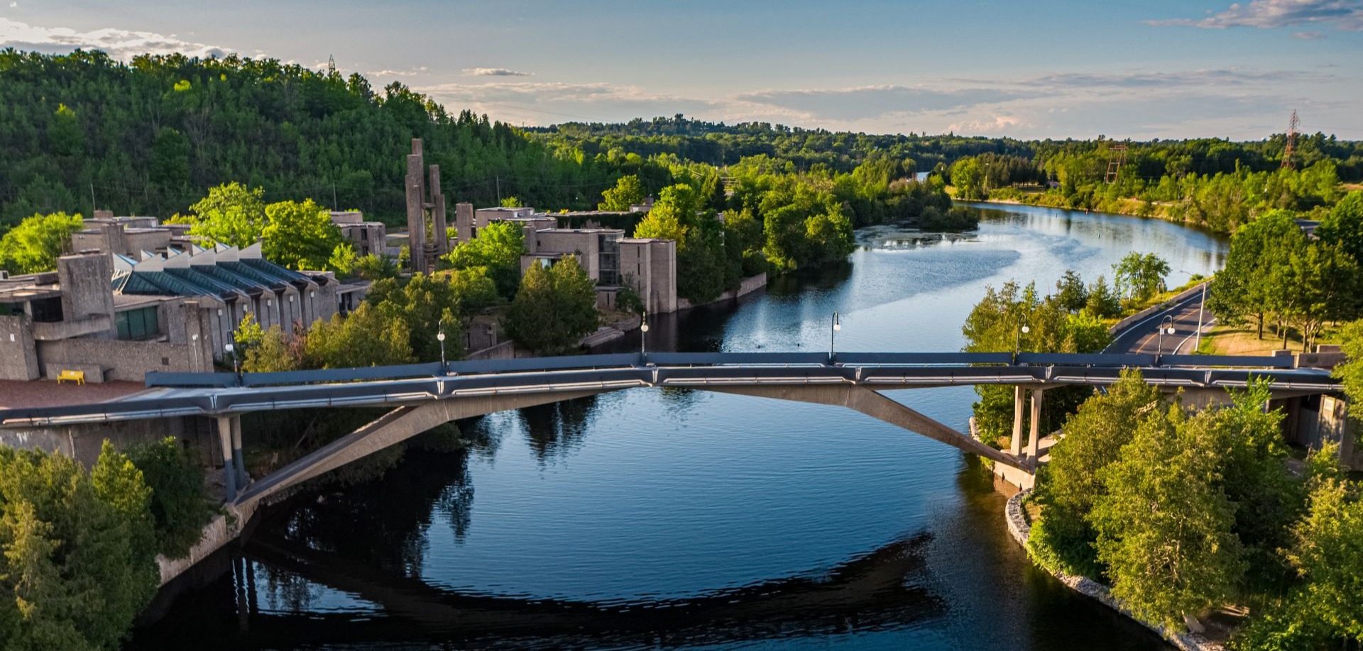 A bird's eye view of the Faryon bridge over the Otonabee River on a summer day.
