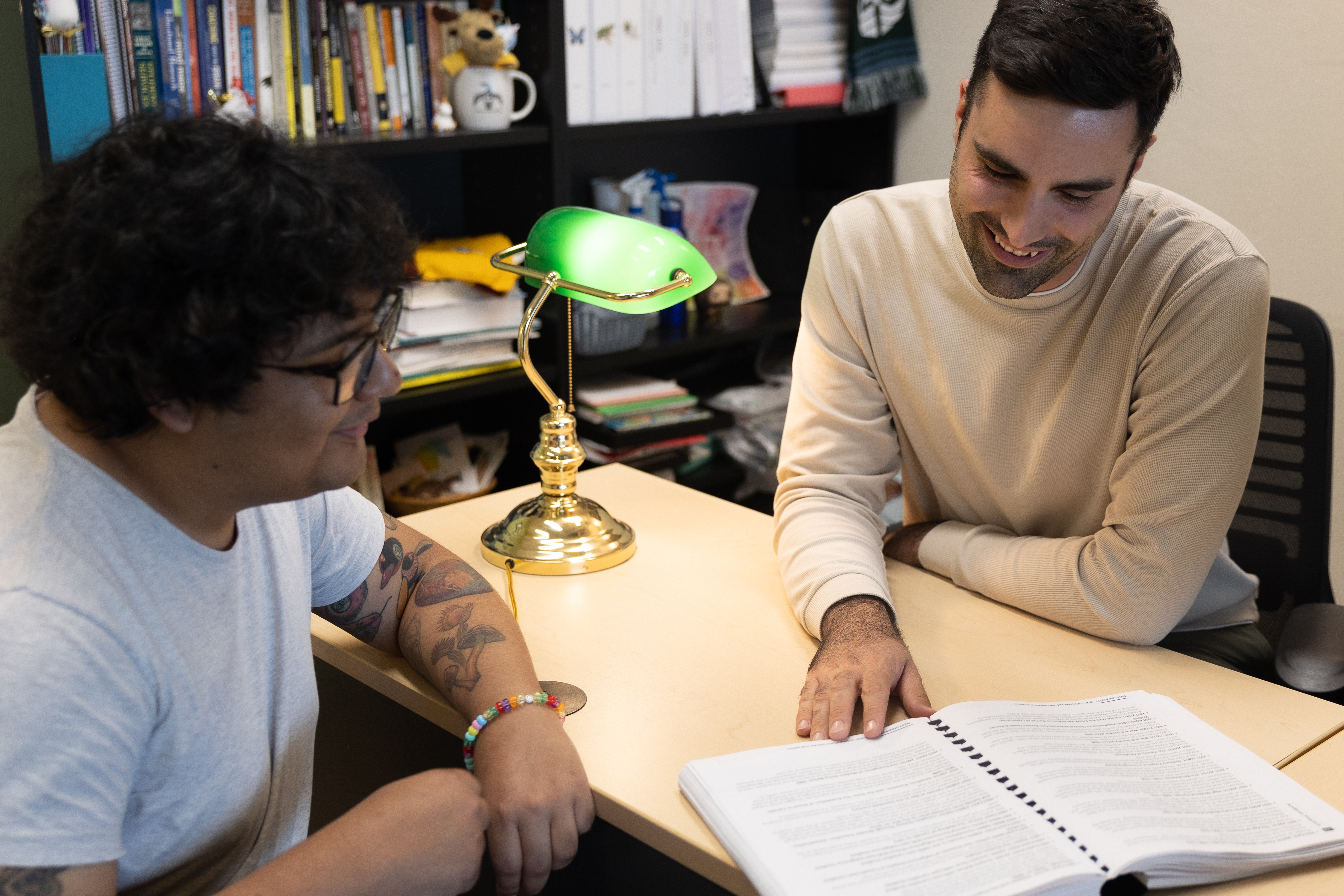 A student and an academic advisor meeting at a desk, reviewing the academic calendar together.
