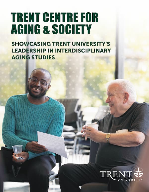 Photo of a senior citizen sitting with a younger man and they are having a good time and laughing