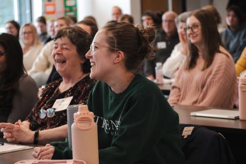 Students and community participants smiling in intergenerational classroom