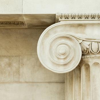 white stone pillar in front of a white stone wall