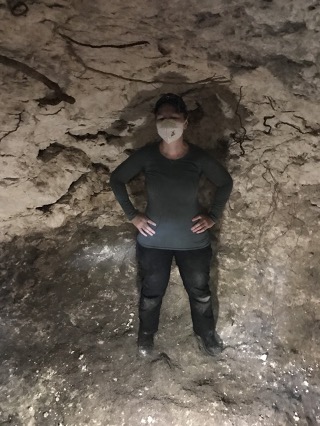 Dr. Newton standing in an excavated chultun (underground chamber) at Ka’kabish, Belize