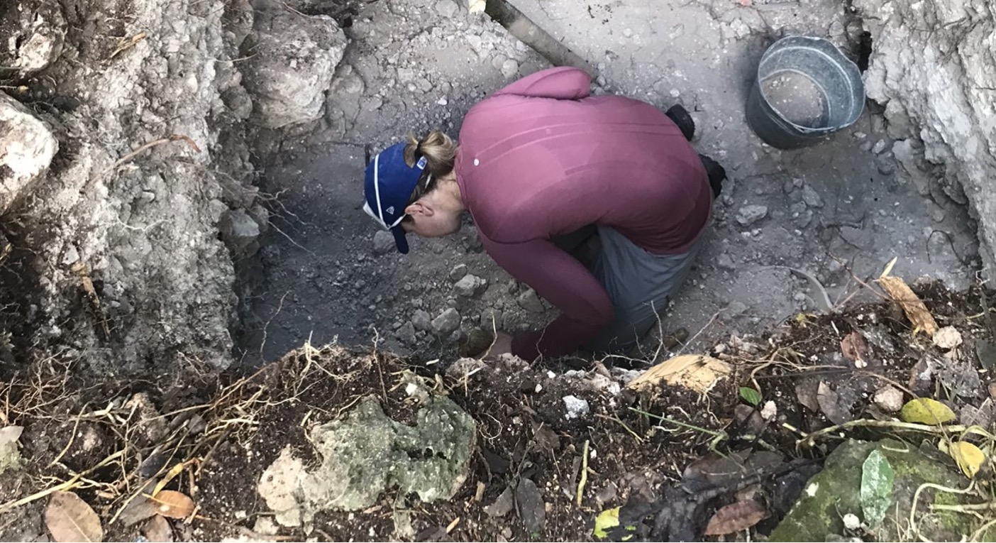 Dr. Newton examining material in an excavation unit at Ka’kabish, Belize