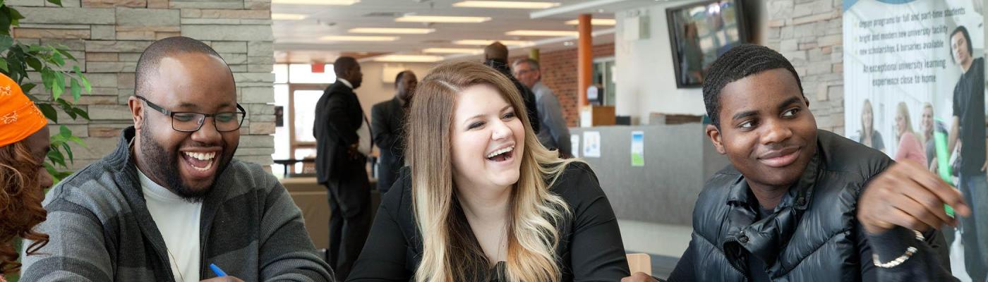 Three students in study in the Atrium at Trent University Durham GTA.