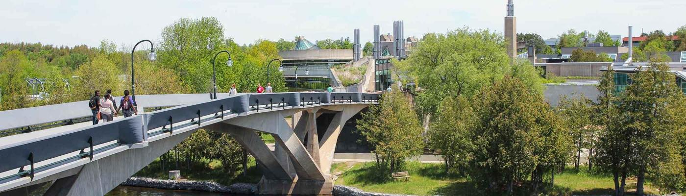 Students walking across Faryon Bridge at Trent University Symons campus.