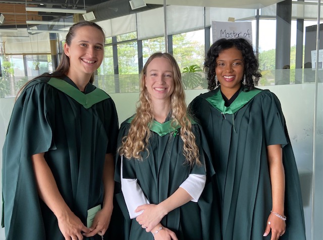 Three students in graduating gowns