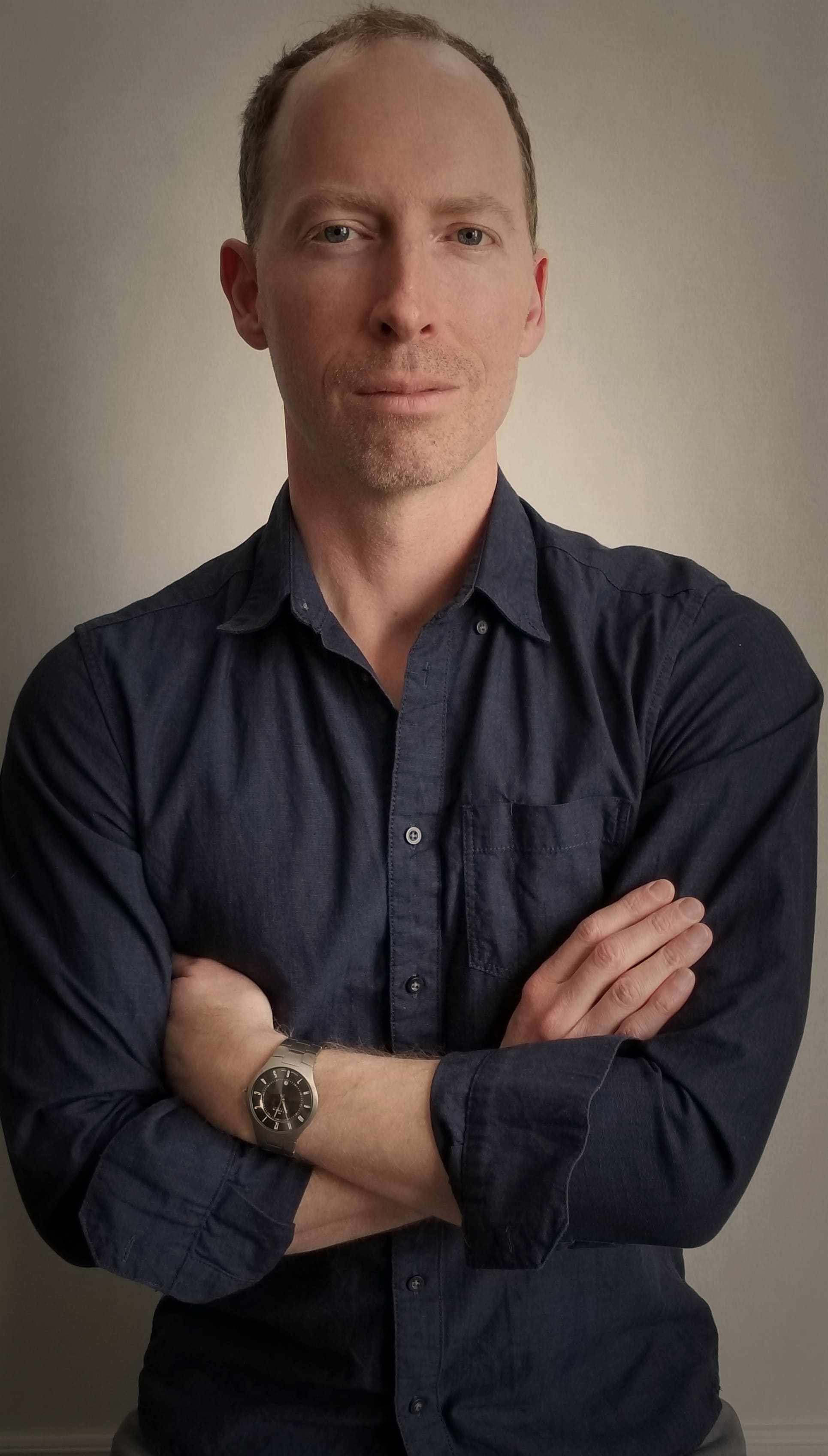 Glen Brown looking at the camera with his arms crossed across his chest. 