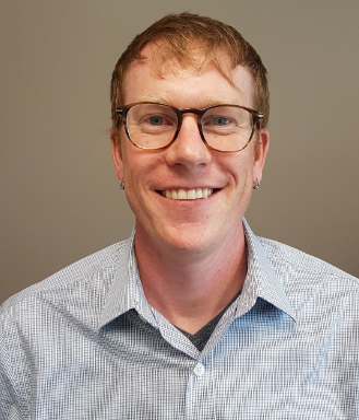 Thomas Hossie smiling with a neutral background