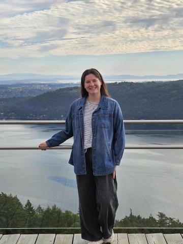 Woman standing on walkway in front of a body of water
