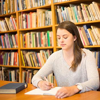 Girl sitting at desk in library