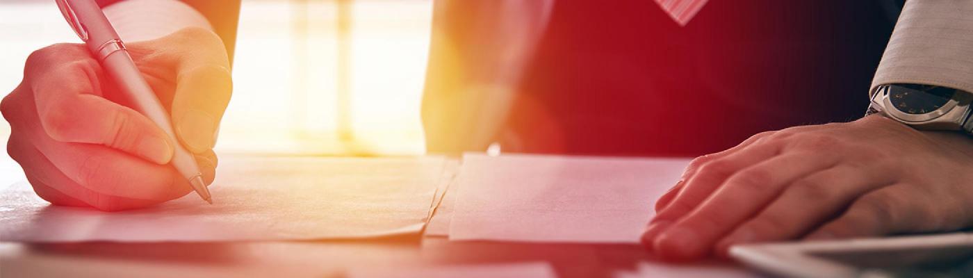 Closeup of man signing paper