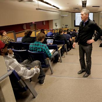 Professor Ray Dart stadning in a lecture hall talking with seated students