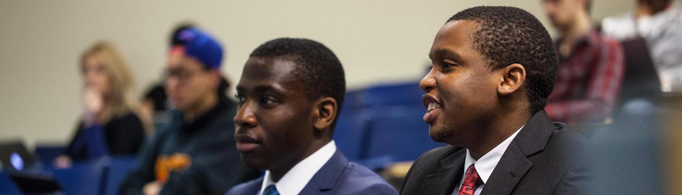 Business students sitting in a lecture hall listening to a lecture