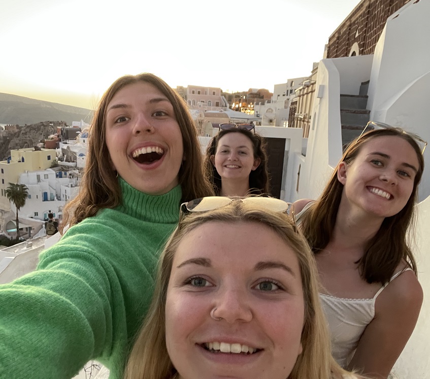 group of smiling people facing camera in front of French Riviera landscape