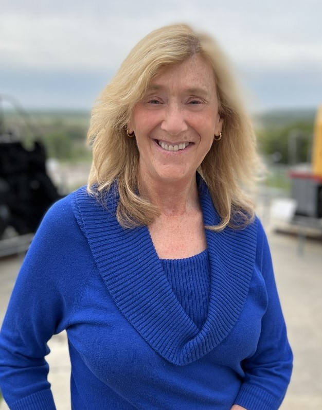 Smiling woman with Blond shoulder length hair and royal blue sweater