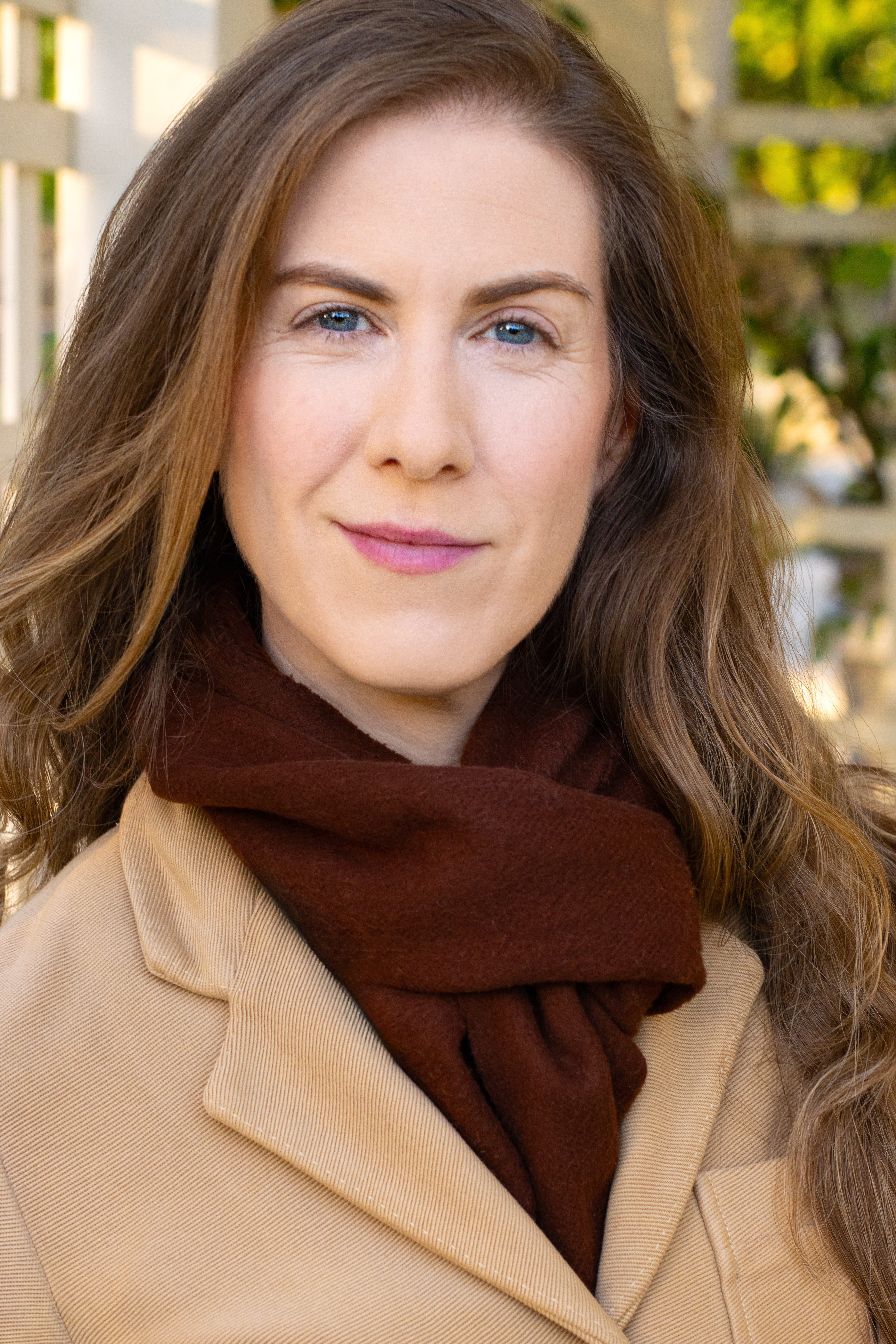 human with long auburn hair smiling at camera