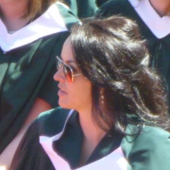MA graduate seated during convocation ceremony on a sunny day