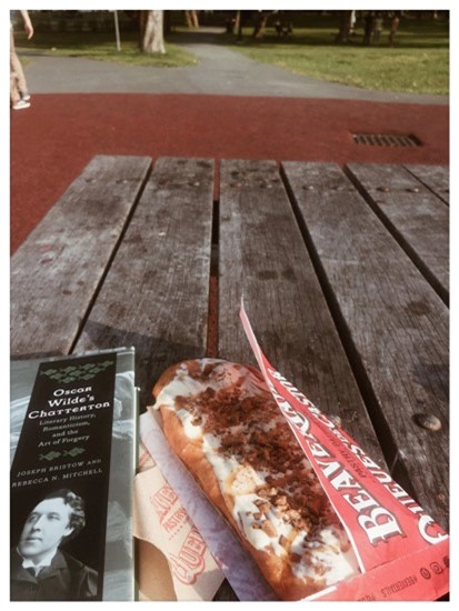 Book and beavertail pastry on wooden table