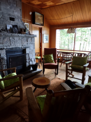 Rustic cabin interior with fireplace and pine wood chairs