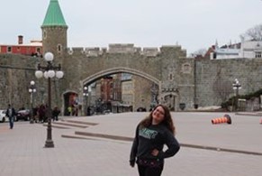 Young person in Trent hoodie in front of wall to Vieux Quebec