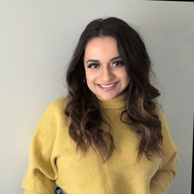 smiling female with dark hair and yellow sweater