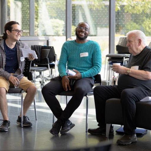 Two students talking with an older adult