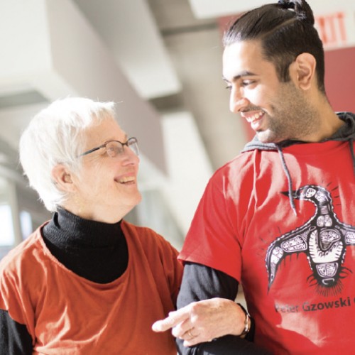 A student walking with an older adult